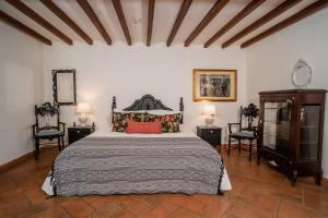 a bedroom with a large bed and two chairs at Hotel Boutique Al Alma in Santa Fe de Antioquia +124 photos