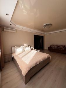 - une chambre avec un grand lit et un plafond dans l'établissement VIP квартира в центре города, à Kostanay