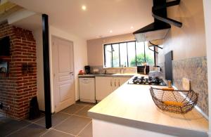a kitchen with a counter and a brick wall at La Forge d'Espérance in Éperlecques