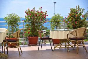 a patio with a table and chairs and flowers at Apartments Raymond in Sveti Stefan