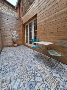 un patio con mesa y sillas en un suelo de baldosa en Charmante maison à Haybes, en Haybes