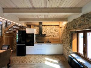 a kitchen with white cabinets and a stone wall at Casas rurales Villa la Roza in La Utrera +24 photos