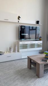 ein Wohnzimmer mit einem TV auf einem weißen Entertainment-Center in der Unterkunft Al Ashkhara Beach House in Al Sharqiyah