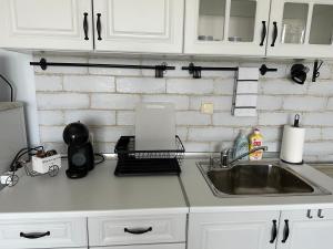 a kitchen counter with a sink and a laptop at Studio E32 Atia Resort Chernomoretz in Chernomorets +7 photos