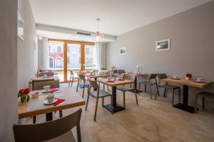 a restaurant with tables and chairs in a room at Villa Carducci in Comacchio