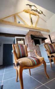 a room with two chairs and a brick fireplace at La Forge d'Espérance in Éperlecques