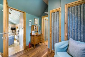 a living room with blue walls and a blue couch at Luxury self catering 1 bed cottage with log burner in Applecross