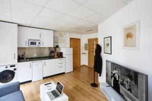 a kitchen and living room with a couch and a tv at Apartamento Moroy in Logroño