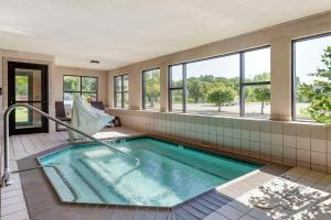 uma banheira de hidromassagem num quarto com janelas em Comfort Suites Grandville em Grandville