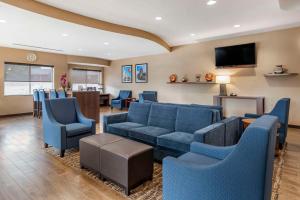 - un salon avec un canapé, des chaises et une télévision dans l'établissement Comfort Suites Airport, à Luckney