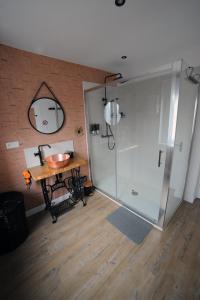 La salle de bains est pourvue d'une douche, d'une table et d'un lavabo. dans l'établissement La Parenthèse du Marquis, à Neufchâtel-en-Bray
