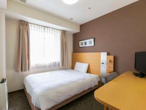 a bedroom with a bed and a desk and a window at Comfort Hotel Osaka Shinsaibashi in Osaka