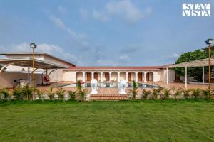 a building with a lawn in front of it at StayVista at Rio Vista with Pool, Lawn, Music Speaker & Game in Neral