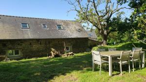 a table and chairs in front of a house at Les gites de koatephani et ses animaux in Gouézec