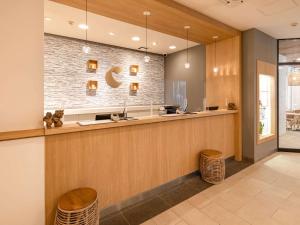 a lobby with a counter and two stools at Comfort Inn Naha Tomari Port in Naha