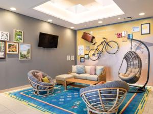 a living room with two chairs and a bike on the wall at Comfort Inn Naha Tomari Port in Naha