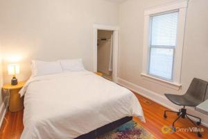 een slaapkamer met een bed, een stoel en een raam bij Charming 3BR - Heart of Seattle in Seattle