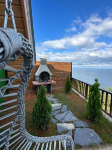 a porch with a bench and a fireplace on a house at Günbatımı Bungalov in Rize