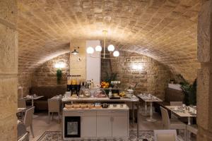 um restaurante com tecto de pedra, mesas e cadeiras em Hôtel Saint Martin Bastille em Paris