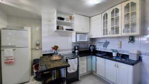 uma cozinha com armários brancos e um frigorífico branco em Ideal para família e grupos, local nota 10 e Wi-fi top! em Brasília