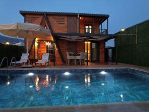 a villa with a swimming pool in front of a house at TÜRKMEN VİLLAS in Demre