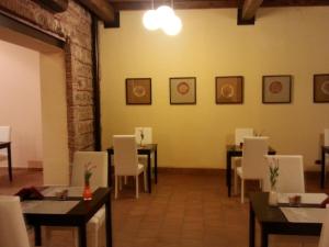 a dining room with tables and white chairs at Art & Jazz Hotel in Catania