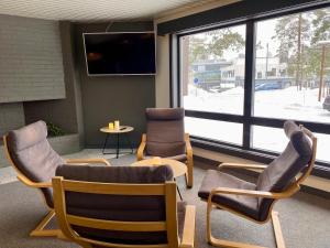 a waiting room with chairs and a tv and a table at Hotell Fritidsparken in Skien