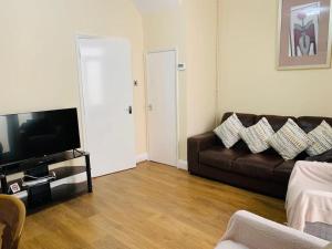 a living room with a couch and a television at Families and contractors Free off road parking in Huntingdon