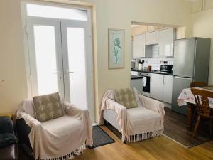a living room with two chairs and a kitchen at Families and contractors Free off road parking in Huntingdon