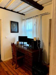 a room with a desk with a computer and a window at Lauku Mickas Country House in Zirņi