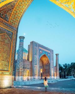 a young girl standing in front of a building at ANNUR Boutique Hotel in Samarkand