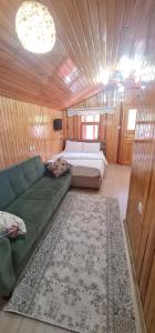 a living room with a couch and a bed at SAHH MOTELl in Uzungol