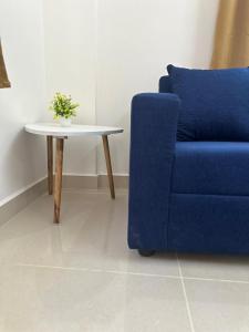 Room2go في بانغالور: أريكة زرقاء وطاولة مع كرسي أزرق