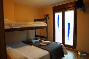 a bedroom with two bunk beds and a window at Adosado en LLanes in Llanes