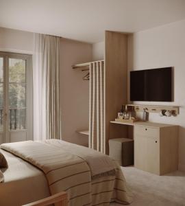 Hotel Casa Teva Barcelona في برشلونة: غرفة نوم مع سرير وتلفزيون على الحائط