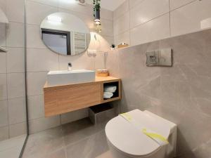 bagno con servizi igienici, lavandino e specchio di Complex Balnear Covasna a Covasna