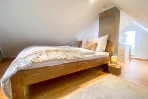 a bedroom with a wooden bed with white sheets and pillows at Ferienhaus Wolff in Barth