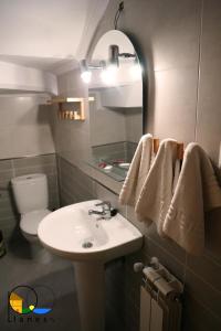 a bathroom with a sink and a toilet and towels at Adosado en LLanes in Llanes +15 photos