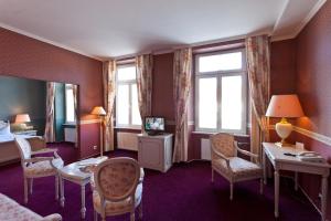 a hotel room with a bed and a table and chairs at Hotel de Weimar in Ludwigslust