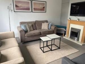 a living room with a couch and a fireplace at Warwick House, 5 bedrooms, 9 beds, parking, garden in Coventry