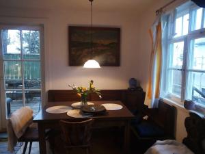 a dining room table with a vase of flowers on it at Ferienwohnung am Walnussbaum in Dießen am Ammersee +25 photos