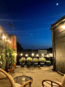 a patio with potted plants and lights at night at Epic Location, Views & Large Private Terrace in Windsor