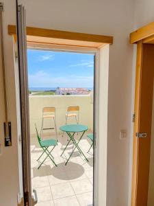 a view of a patio with chairs and a table at Seaside room in a Peniche townhouse featuring a private bathroom and shared access to the swimming pool and kitchen in Atouguia da Baleia