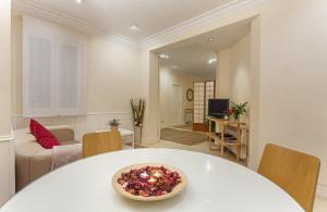 ein Wohnzimmer mit einem weißen Tisch und einer Schüssel darauf in der Unterkunft Apartamento Prado en Madrid in Madrid