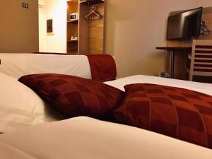 a brown pillow sitting on top of two beds at Bes Hotel Bergamo Ovest in Mozzo