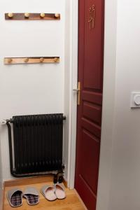 a pair of sandals next to a door with a radiator at New Flat near Paris with Secure Parking 7' to RER B direct line CDG ORY in Le Plessis-Robinson