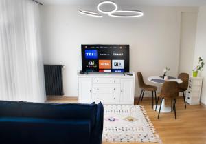 a living room with a tv and a table with chairs at New Flat near Paris with Secure Parking 7' to RER B direct line CDG ORY in Le Plessis-Robinson