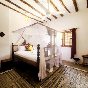 sypialnia z łóżkiem z baldachimem w obiekcie MARS A.K. VILLAS w mieście Jambiani