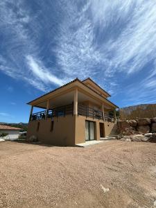 a house with a balcony on top of it at ISULA PETRA in Porto-Vecchio