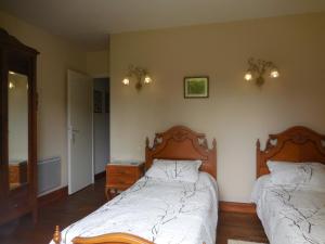 1 dormitorio con 2 camas, tocador y espejo en La Madriguera Accommodation, en Gardes-le-Pontaroux